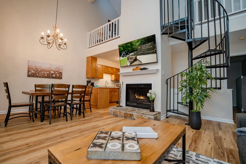Unwind in this soaring, light-filled space where rustic charm meets modern comfort. The cozy fireplace, spiral staircase, and open-plan design create an inviting retreat for your mountain getaway.