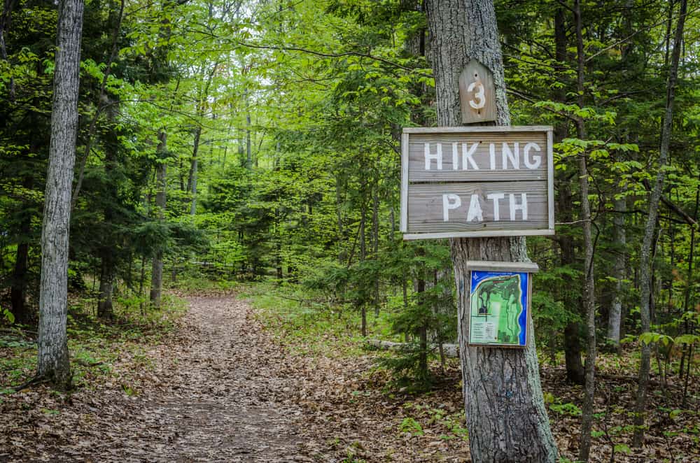A sign indicates the entrance to a hiking trail.